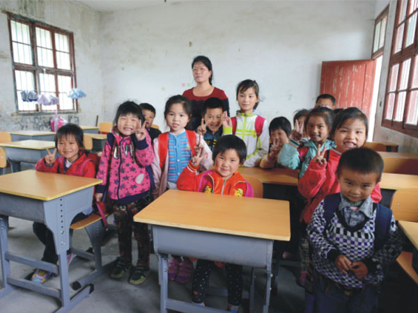 公司為一山村小學捐贈一批課桌椅，孩子們高興地和老師一起合影